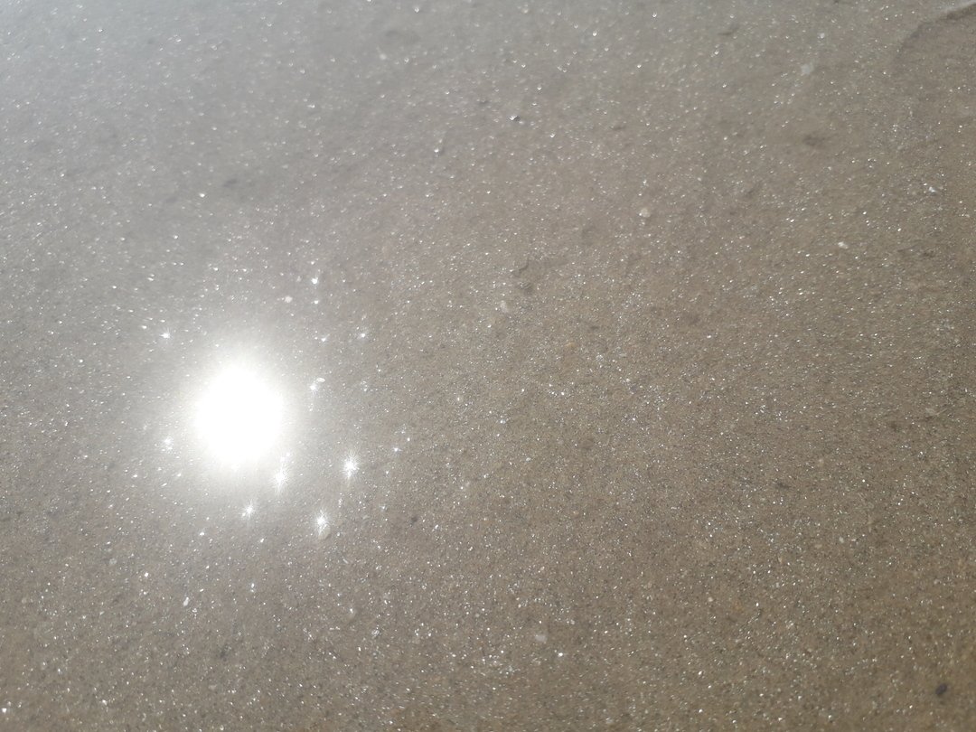 Vue de détail du sable d'une plage bretonne qui scintille de mille feux