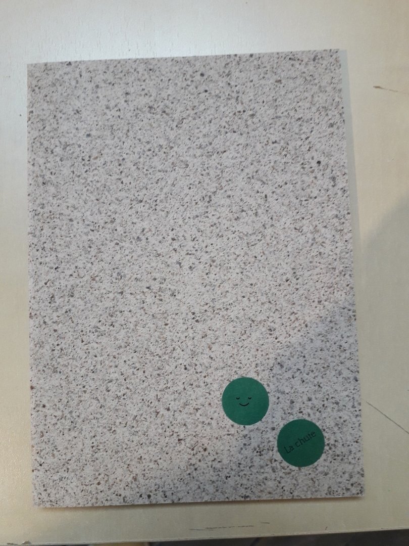 Image 40 : Chute de papier sur laquelle a été aposé un sticker avec un smiley et un autre avec la mention La chute 
