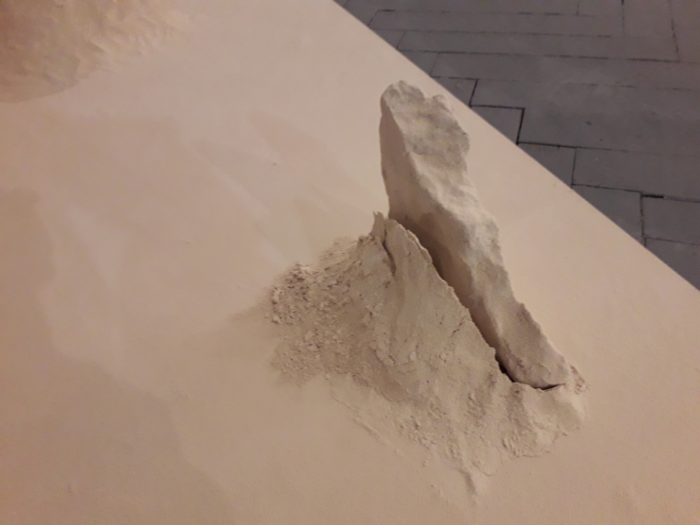 Sculpture délicate et abstraite émergeant d'un pan lisse