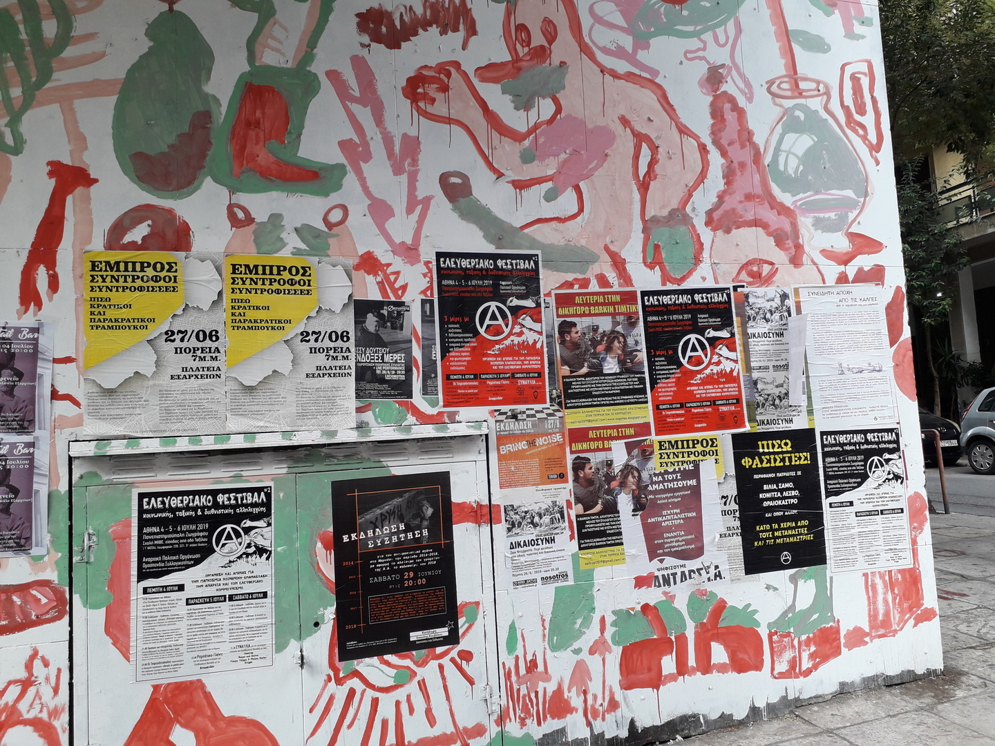 Mur avec des peintures et des affiches dont la plupart des contenus sont anarchistes