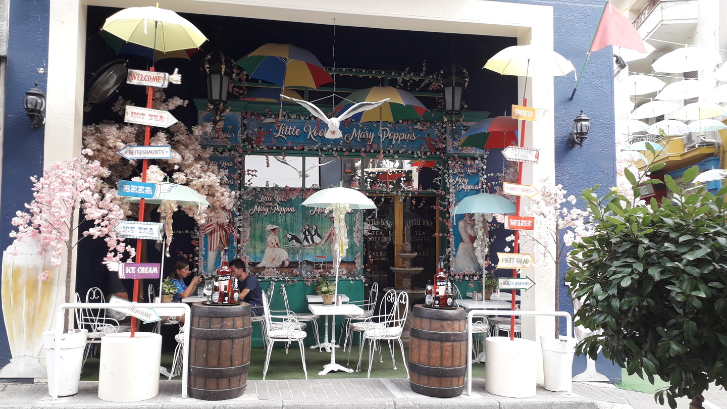 Terrasse d'un café avec parapluies, oiseaux et autres suspensions fantaisistes