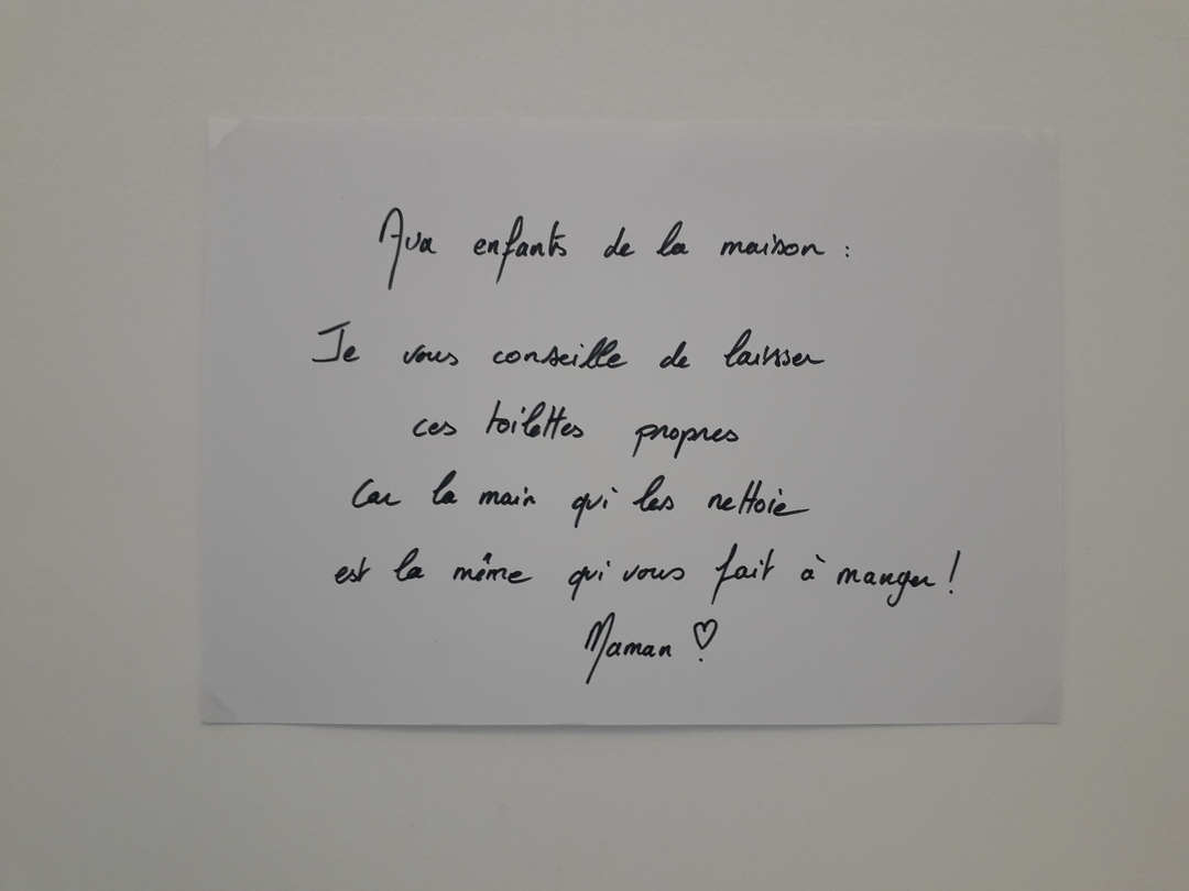 Image 1 : Petit papier au-dessus des toilettes avec une inscription manuscrite