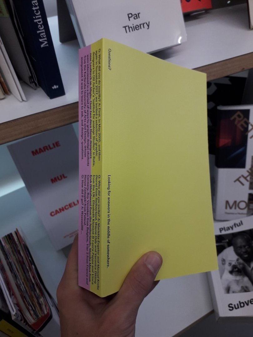 Livre avec une couverture jaune et l'autre rose intitulé Questions? Looking for answers in the middle of somewhere.