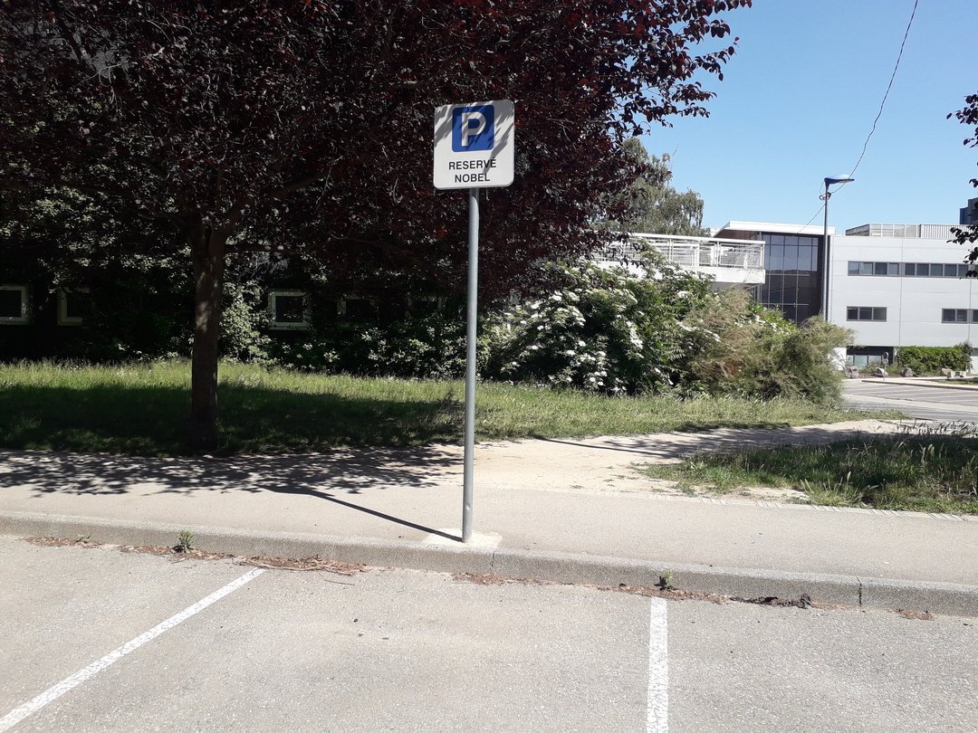 Place de parking avec un panneau Réservé nobel